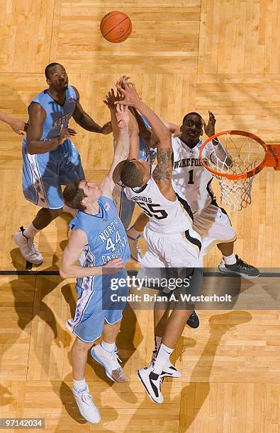 Tony Woods and Al-Farouq Aminu of the Wake Forest Demon Deacons battle for a rebound with Tyler Zeller of the North Carolina Tar Heels on February...
