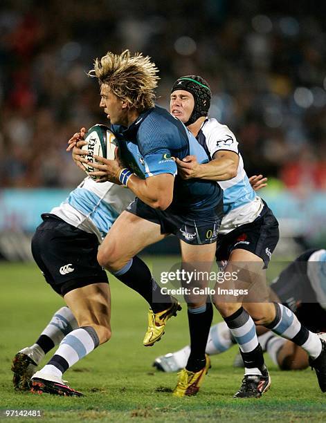 Wynand Olivier of the Bulls is tackled by Berick Barnes of the Waratahs during the round three Super 14 match between Bulls and Waratahs at Loftus...