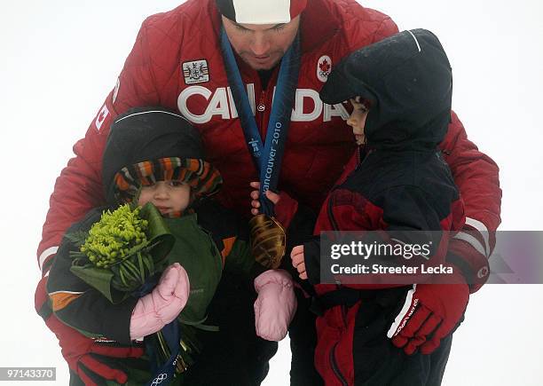 Jasey Jay Anderson of Canada poses with his children after winning the gold medal in the Snowboard Men's Parallel Giant Slalom on day 16 of the...