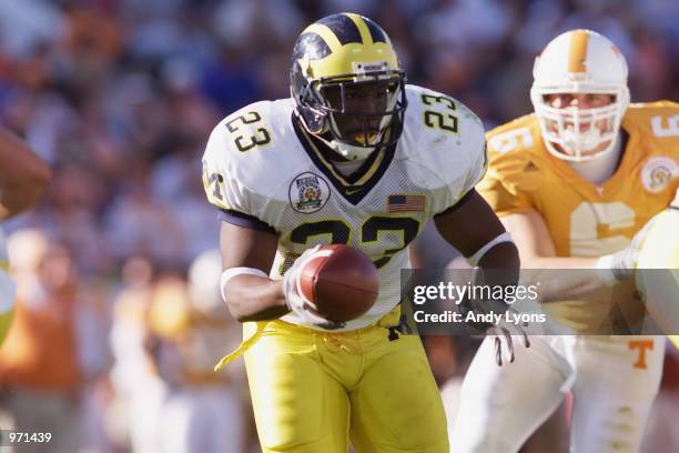 Running back Chris Perry of the Michigan Wolverines hands off on a reverse during the Citrus Bowl against the Tennessee Volunteers on January 1, 2002...