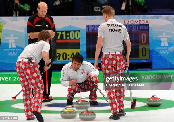 Norway's skip Thomas Ulsrud examine the stone formation inside a circle next to his teammate sweepers as Canada's skip Kevin Martin look on during...