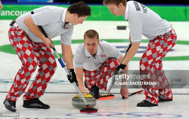 Norway's Haavard Vad Petersson releases a stone as his teammates sweep during their Vancouver Winter Olympics men's curling gold medal match against...