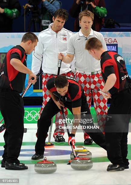 Norway's skip Thomas Ulsrud and his teammate Torger Nergaard monitor Canadian players move during their Vancouver Winter Olympics men's curling gold...