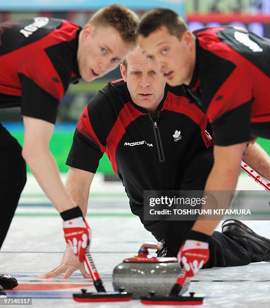 Canada's Kevin Martin and sweepers, Marc Kennedy and Ben Hebert check the direction during their Vancouver Winter Olympics men's curling gold medal...