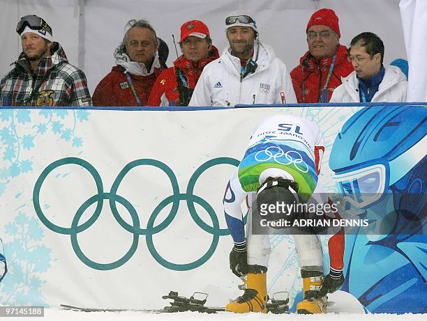 Bronze medalist Mathieu Bozzetto of France adjusts his boots while the coaches look on following a race during the Men's Freestyle Skiing Snowboard...