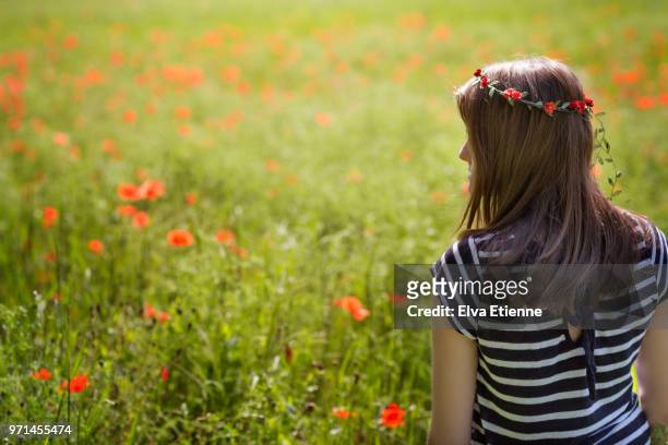 teenage girl standing in a field of red poppies - stehmohn stock-fotos und bilder