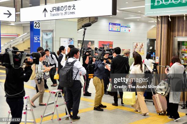 Media reporters surround passengers arriving at Shin Osaka station after a knife-wielding man attacked and killed a male passenger and seriously...