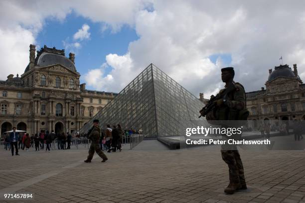 French soldiers patrol inside the Louvre Palace in front of the Pyramid designed by I.M. Pei. Paris is on an almost permanent security alert...