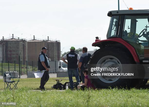Unionists stand near a tractor as French National federation of Agricultural Holders Unions and Young Farmers union members block the access of a...