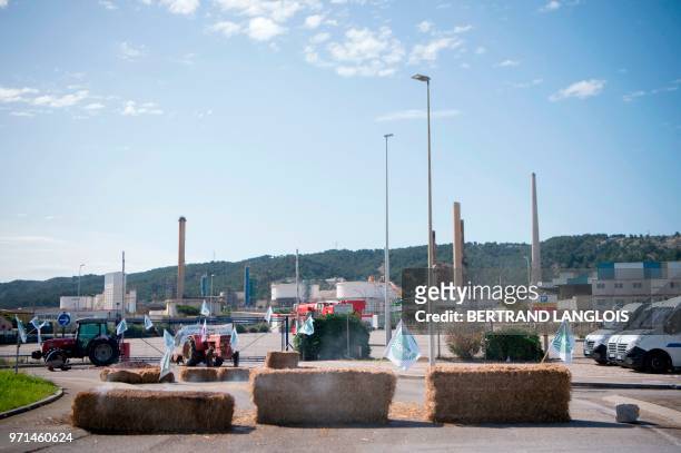 Picture taken in Chateauneuf-les-Martigues, southern France, on June 11, 2018 shows straw bales blocking the access of French oil giant Total's La...