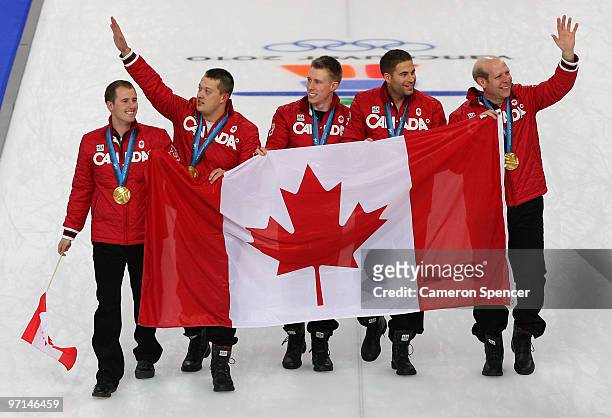 Adam Enright, Ben Hebert, Marc Kennedy, John Morris and Kevin Martin of Canada walk on the ice with the Canadian flag and their gold medals after the...