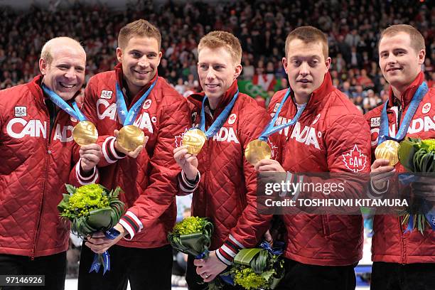 Canada's curling team Canada's Kevin Martin, John Morris, Marc Kennedy, Ben Hebert and Adam Enright display their gold medal on the podium during the...