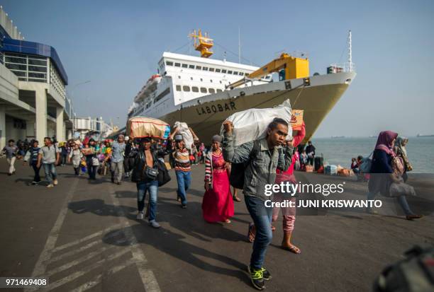 Passengers disembark from a ship on arrival at the Surabaya port in East Java on June 11 as people travel to their hometowns to celebrate the Eid...