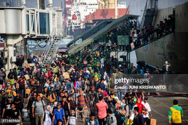 Passengers disembark from a ship on arrival at the Surabaya port in East Java on June 11 as people travel to their hometowns to celebrate the Eid...