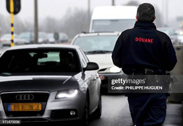 Lille's French customs officer looks at vehicles on February 3, 2011 at the Rekkem Franco-Belgian border checkpoint in Neuville-en-Ferrain, northern...