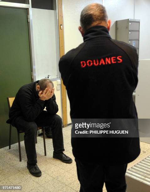 Man who was carrying about 50g of cannabis holds his head in his hands after being arrested by Lille's French customs on February 3, 2011 at the...