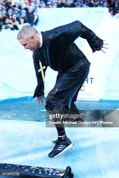 Lions head coach Chris Fagan falls after he goes down the MND slide during the round seven AFL match between the Western Bulldogs and the Gold Coast...