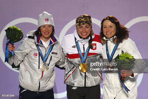 Marit Bjoergen of Norway celebrates her Silver medal, Justyna Kowalczyk of Poland Gold, and Aino-Kaisa Saarinen of Finland Bronze during the medal...