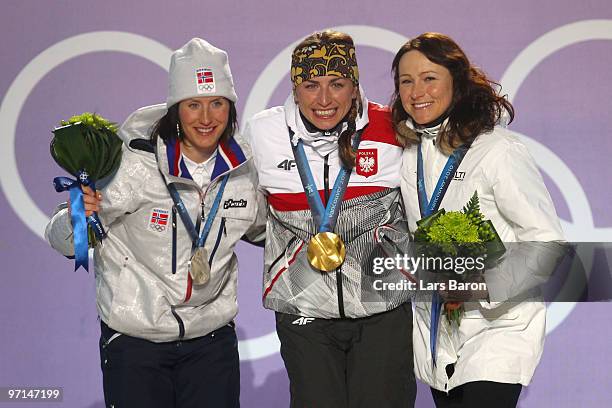 Marit Bjoergen of Norway celebrates her Silver medal, Justyna Kowalczyk of Poland Gold, and Aino-Kaisa Saarinen of Finland Bronze during the medal...