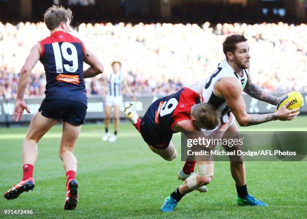 Jeremy Howe of the Magpies withstands a tackle from Charlie Spargo of the Demons during the round seven AFL match between the Western Bulldogs and...
