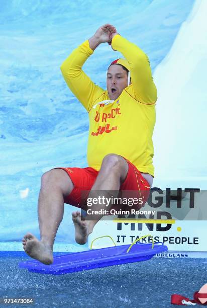 Suns head coach Stuart Dew goes down the Freeze MND slide during the round 12 AFL match between the Melbourne Demons and the Collingwood Magpies at...