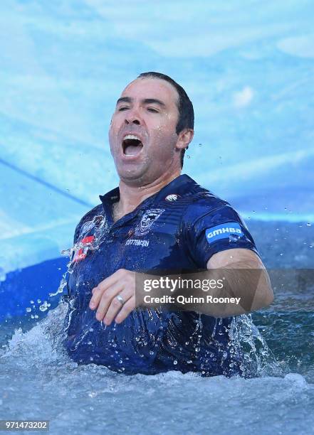 Kangaroos head coach Brad Scott goes down the Freeze MND slide during the round 12 AFL match between the Melbourne Demons and the Collingwood Magpies...