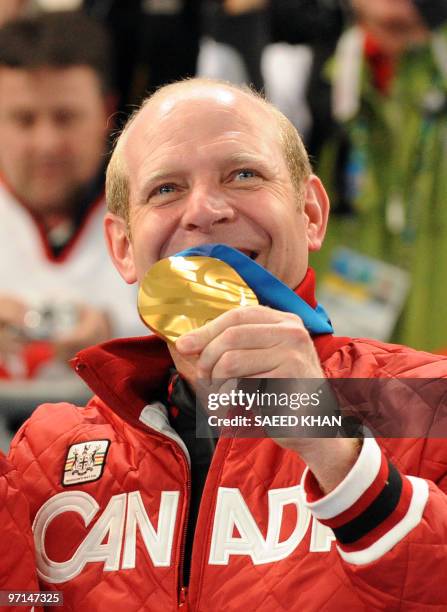 Canada's skip Kevin Martin shows his gold medal on the podium during the medals ceremony after the Vancouver Winter Olympics men's curling final...