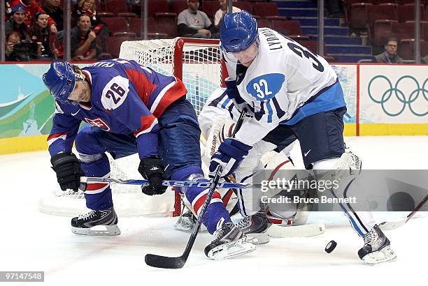 Michal Handzus of Slovakia fights for the puck against Toni Lydman of Finland during the ice hockey men's bronze medal game between Finland and...