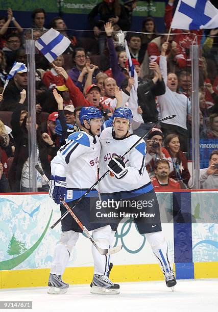 Sami Salo of Finland celebrates with Mikko Koivu after scoring a goal in the first period during the ice hockey men's bronze medal game between...