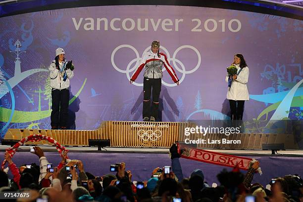 Marit Bjoergen of Norway celebrates her Silver medal, Justyna Kowalczyk of Poland Gold, and Aino-Kaisa Saarinen of Finland Bronze during the medal...