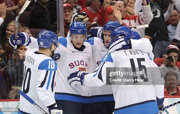 Sami Salo of Finland celebrates with Mikko Koivu and his team after scoring a goal in the first period during the ice hockey men's bronze medal game...