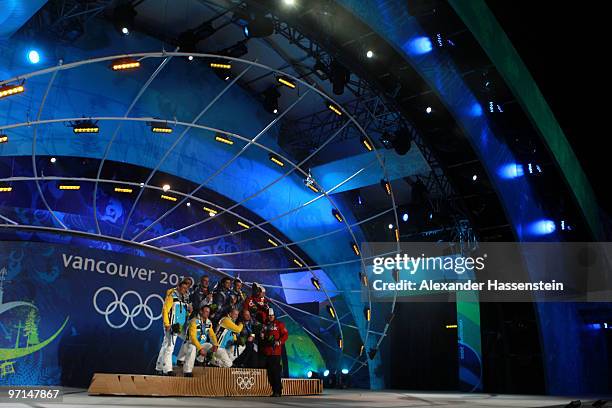 Team Germany celebrates their Silver medal, Team USA Gold and Team Canada Bronze during the medal ceremony for the Men's Four-Man Bobsleigh on day 16...