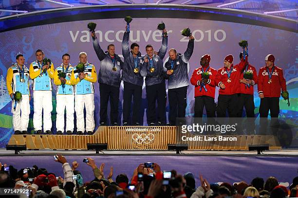Team Germany celebrates their Silver medal, Team USA Gold and Team Canada Bronze during the medal ceremony for the Men's Four-Man Bobsleigh on day 16...