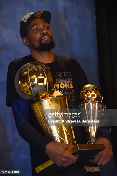 Kevin Durant of the Golden State Warriors poses for a portrait with the Larry O'Brien Championship trophy and the Bill Russell Finals MVP trophy...