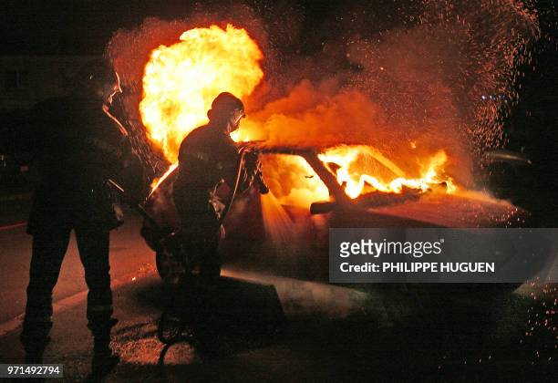 Firemen try to extinguish a car set ablaze by protestors, 06 May 2007 in the French northern city of Lille, during a demonstration after the victory...