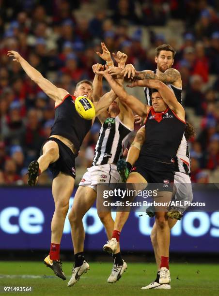 Jeremy Howe of the Magpies and Cameron Pedersen of the Demons compete for the ball during the round 12 AFL match between the Melbourne Demons and the...