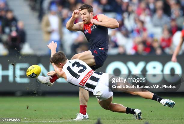 Jack Viney of the Demons has his kick blocked by Taylor Adams of the Magpies during the round 12 AFL match between the Melbourne Demons and the...