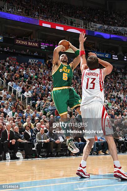 Carlos Boozer of the Utah Jazz puts the shot up over David Andersen of the Houston Rockets at EnergySolutions Arena on February 27, 2010 in Salt Lake...