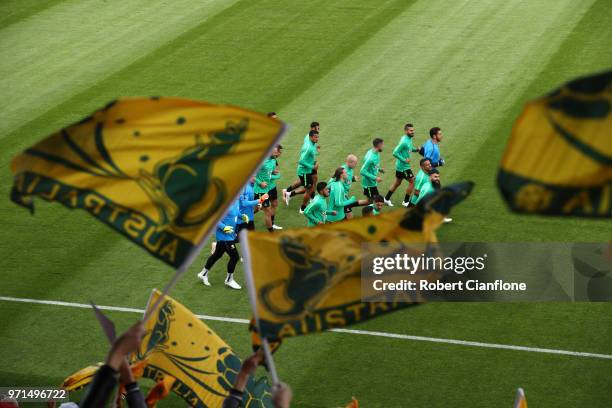 Fans wave flags in support as the Australia team warm up, during an Australian Socceroos training session ahead of the FIFA World Cup 2018 in Russia...