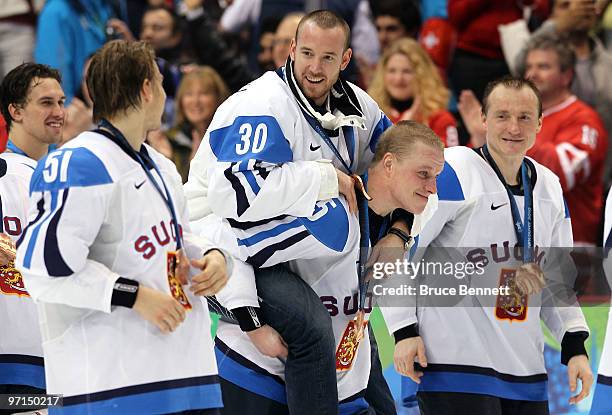 Lasse Kukkonen of Finland celebrates Antero Niittymaki with the medal after the ice hockey men's bronze medal game between Finland and Slovakia on...