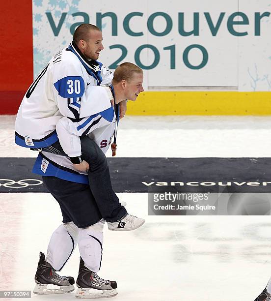 Lasse Kukkonen of Finland celebrates Antero Niittymaki with the medal after the ice hockey men's bronze medal game between Finland and Slovakia on...