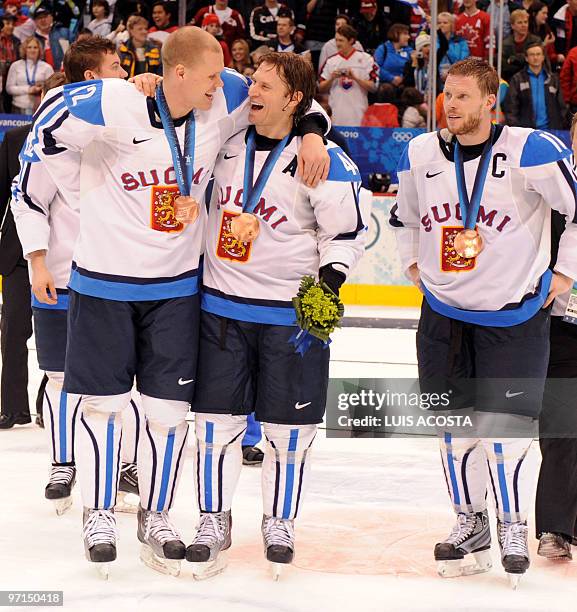 Finland's Olli Jokinen, Kimmo Timonen and Saku Koivu celebrate after victory over Slovakia during the men's bronze medal Ice Hockey match at Canada...