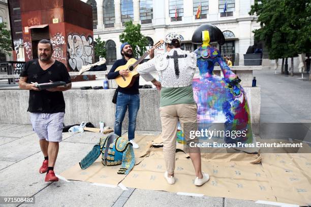 The artist Domingo Zapata next to two street musicians after restoring his artwork, the menina 'La vida es sueno', in front of Queen Sofia Museum on...