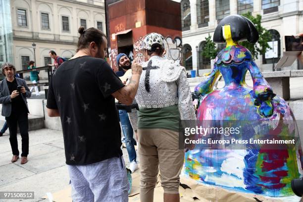 The artist Domingo Zapata paints the torero jacket of an street musician after restoring his artwork, the menina 'La vida es sueno', in front of...