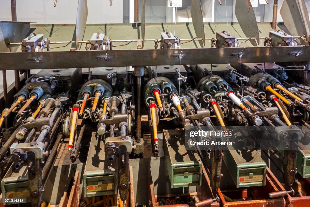 Bobbins with yarns on spool machine in cotton mill.