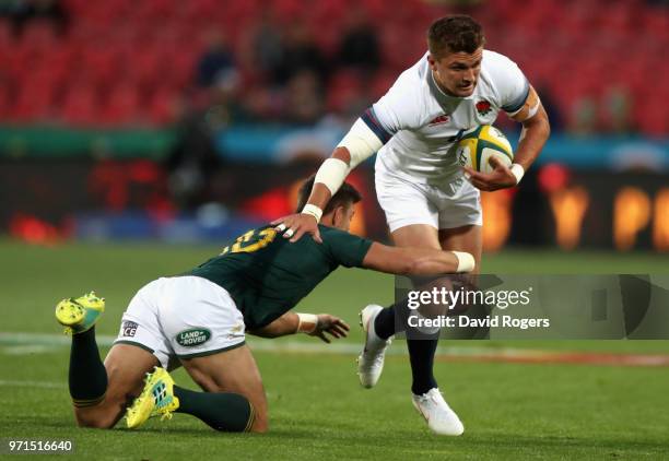 Henry Slade of England is tackled by Handre Pollard during the first test match between South Africa and England at Elllis Park on June 9, 2018 in...
