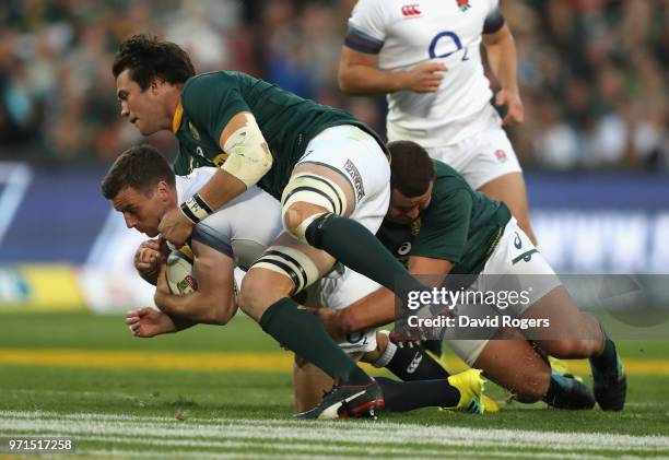 George Ford of England is tackled by Franco Mostert during the first test match between South Africa and England at Elllis Park on June 9, 2018 in...