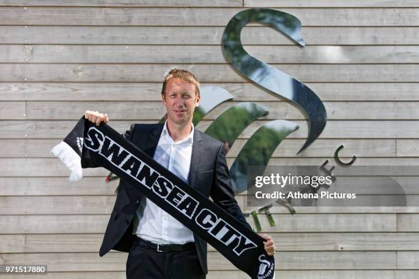 Graham Potter holds a team scarf during the unveiling of the new manager Graham Potter at The Fairwood Training Ground on June 11, 2018 in Swansea,...