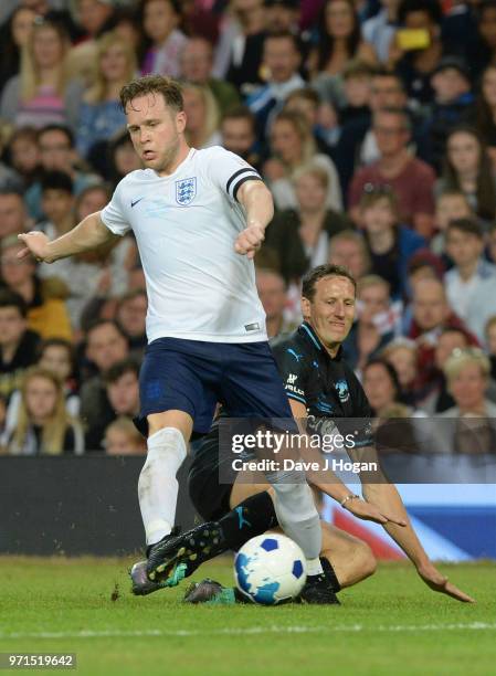 Olly Murs is tackled by Brendan Cole during Soccer Aid for Unicef 2018 at Old Trafford on June 10, 2018 in Manchester, England at Old Trafford on...