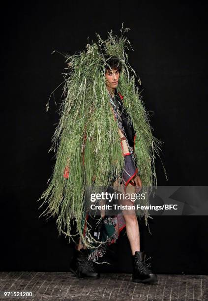 Model walks the runway wearing designs by Robert Newman at the University of Westminster MA Menswear show during London Fashion Week Men's June 2018...